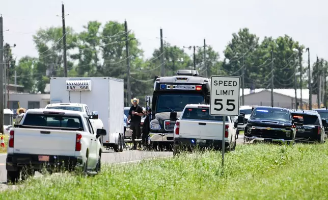 Emergency vehicles parked outside the Butler Memorial Airport after a plane crash in Butler, Mo., Sunday, June 14, 2026. (AP Photo/Reed Hoffmann)