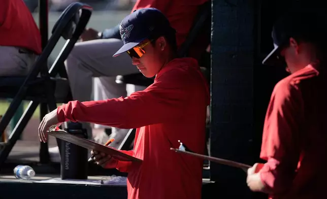 Stockton Ports' Shotaro Morii, left, holds a clipboard in the dugout before a Single A minor league baseball game between the Ports and the San Jose Giants, May 20, 2026, in San Jose, Calif. (AP Photo/Jeff Chiu)