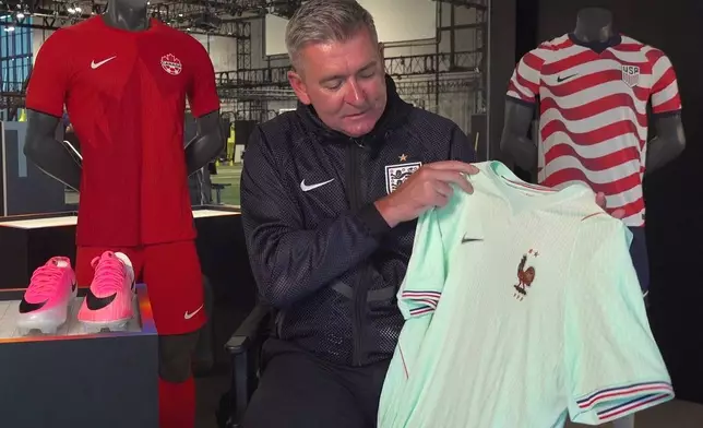 Phil McCartney, chief innovation, design and product officer for Nike, holds up the away jersey for France that the company designed for the World Cup during an interview at Nike headquarters in Beaverton, Ore., on June 22, 2026. (AP Photo/Claire Rush)