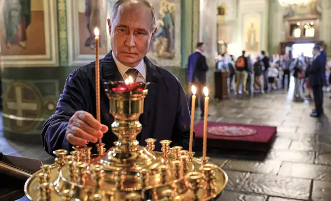 Russian President Vladimir Putin lights a candle while visiting the Annunciation Cathedral of the Kazan Kremlin during the Russia-ASEAN summit in Kazan, Russia, Wednesday, June 17, 2026. (Mikhail Metzel/Sputnik, Kremlin Pool Photo via AP)