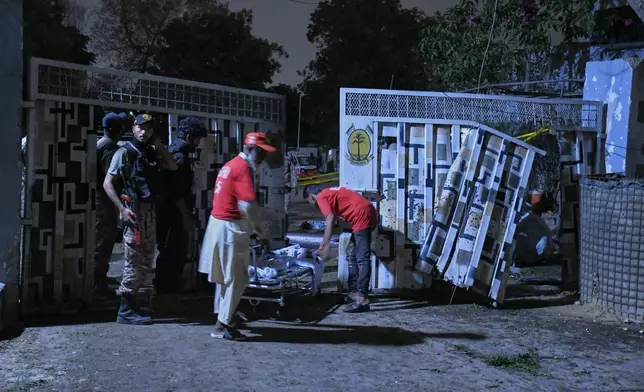 Rescue workers remove a body in Karachi, Pakistan, Sunday, June 28, 2026. (AP Photo/Ali Raza)