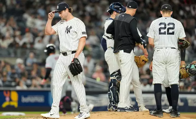 New York Yankees pitcher Gerrit Cole, left, is pulled from the game during the sixth inning of a baseball game against the Cleveland Guardians, Wednesday, June 3, 2026, in New York. (AP Photo/Seth Wenig)