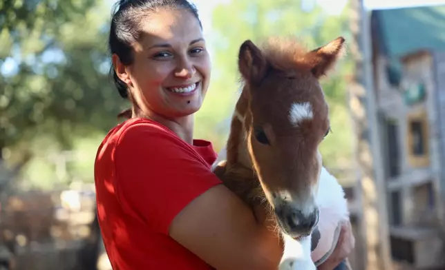 Owner Andjelka Josipovic poses with a pony named Mile at a ranch in Bale, Croatia, on June 13, 2026. (AP Photo)