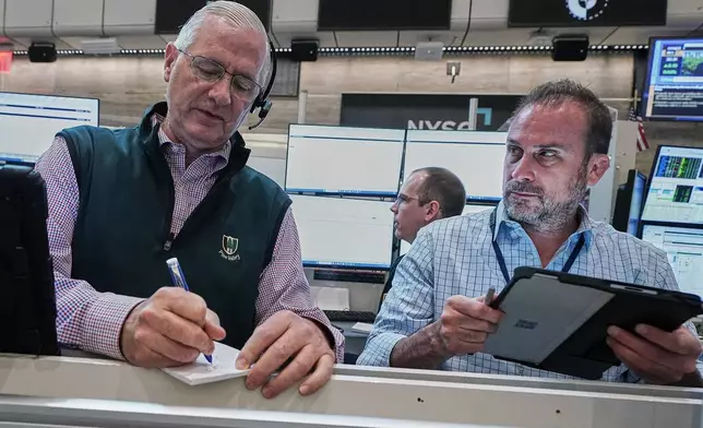 Options traders David Rush, left, and Scott Frinzi work on the floor of the New York Stock Exchange, Tuesday, June 16, 2026. (AP Photo/Richard Drew)