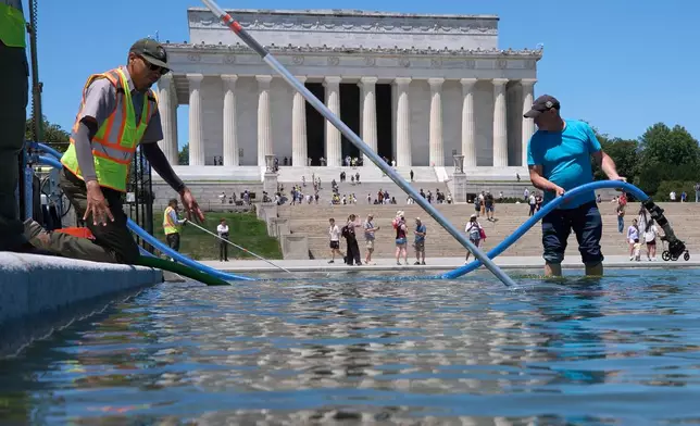 Members of the National Park Service and contractors place a tube into the Lincoln Memorial Reflecting Pool, as the pool is cleaned of algae, Tuesday, June 16, 2026, in Washington. (AP Photo/Jacquelyn Martin)