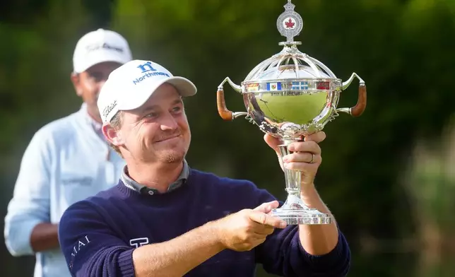 Bud Cauley, of the United States, holds the trophy after winning the Canadian Open golf tournament in Caledon, Ontario, Sunday June 14, 2026. (Frank Gunn/The Canadian Press via AP)