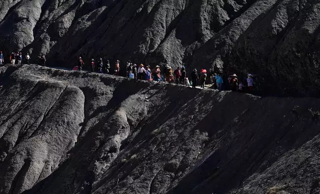 People walk towards a impromptu market in Avircato, Bolivia, set up by producers who are unable to transport their vegetables into the city because of protest blockades, Thursday, June 4, 2026. (AP Photo/Juan Karita)