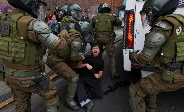 Police detain a student during a protest against the government's proposal to lower the education budget, in Santiago, Chile, Wednesday, June 3, 2026. (AP Photo/Esteban Felix)