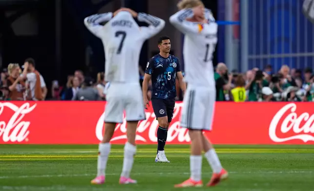 Paraguay's Fabian Balbuena (5) looks on as German players react during a penalty shootout at the end of during the World Cup round of 32 soccer match between Germany and Paraguay in Foxborough, Mass., near Boston, Monday, June 29, 2026. (AP Photo/Petr David Josek)