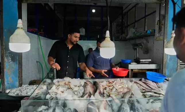 Safeer Mohammed Koorimannil walks through a wholesale fish market before opening his CM Fisheries office in Sulthan Bathery in the southern state of Kerala, India, Thursday, March 12, 2026. (AP Photo/Manish Swarup)