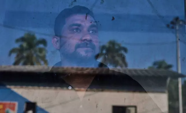 Safeer Mohammed Koorimannil, who was trafficked into scamming, looks out from the window of his CM Fisheries office before starting the day, in Sulthan Bathery in the southern state of Kerala, India, Thursday, March 12, 2026. (AP Photo/Manish Swarup)