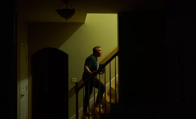 Chris Colocousis, who is still so shaken by a scam that took his retirement savings that he sometimes has trouble leaving his house, turns in for the night at his home in Raynham, Mass., Tuesday, March 10, 2026. (AP Photo/David Goldman)