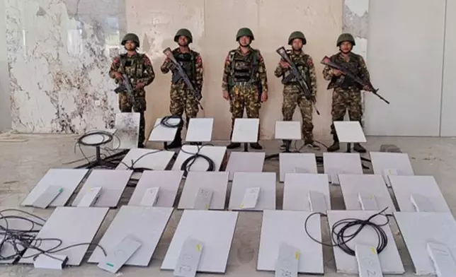 FILE - In this image provided by the Myanmar military on Oct. 19, 2025, soldiers stand next to Starlink satellite internet devices from the KK Park scam compound in Myawaddy township, Karen State, Myanmar. (The Myanmar Military True News Information Team via AP, File)
