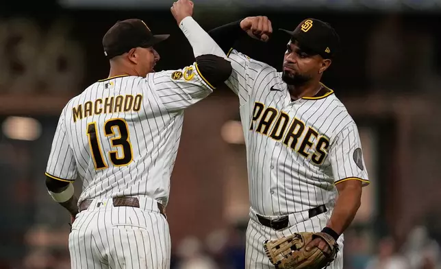 San Diego Padres third baseman Manny Machado (13) celebrates with shortstop Xander Bogaerts after the Padres defeated the Atlanta Braves 1-0 in a baseball game Monday, June 22, 2026, in San Diego. (AP Photo/Gregory Bull)