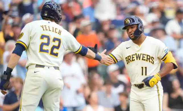 Milwaukee Brewers' Jackson Chourio (11) high-fives Christian Yelich (22) after hitting a two-run home run during the fifth inning of a baseball game against the San Francisco Giants, Thursday, June 4, 2026, in Milwaukee. (AP Photo/Kayla Wolf)