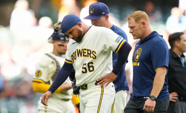 Milwaukee Brewers pitcher Grant Anderson (56) walks off the field with a team trainer after getting hit by a batted ball during the seventh inning of a baseball game against the San Francisco Giants, Thursday, June 4, 2026, in Milwaukee. (AP Photo/Kayla Wolf)