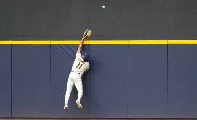 Milwaukee Brewers left fielder Jackson Chourio (11) reaches for a grand slam hit by San Francisco Giants Eric Haase during the seventh inning of a baseball game Thursday, June 4, 2026, in Milwaukee. (AP Photo/Kayla Wolf)