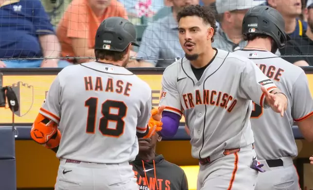 San Francisco Giants' Willy Adames, right, congratulates Eric Haase (18) after Haase hit a grand slam during the seventh inning of a baseball game against the Milwaukee Brewers, Thursday, June 4, 2026, in Milwaukee. (AP Photo/Kayla Wolf)