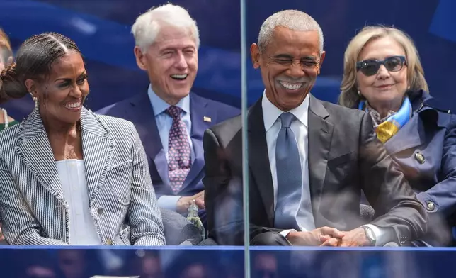 Former President Barack Obama, right, shares a laugh with former first lady Michelle Obama, left, on stage during the dedication ceremony for the Obama Presidential Center, Thursday, June 18, 2026, in Chicago. (AP Photo/Jeff Roberson)