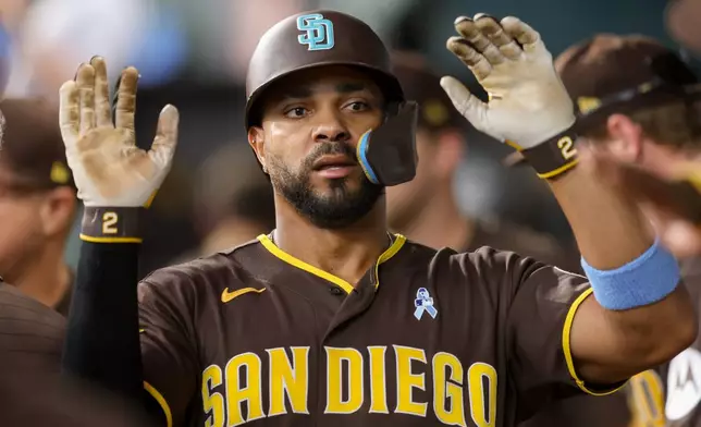 San Diego Padres' Xander Bogaerts (2) celebrates in the dugout after scoring during the fourth inning of a baseball game against the Texas Rangers, Sunday, June 21, 2026, in Arlington, Texas. (AP Photo/Gareth Patterson)