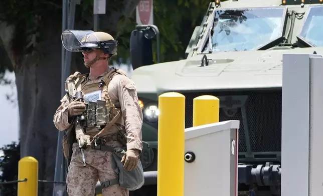 FILE - A U.S. Marine patrols outside of a federal building, June 13, 2025, in Los Angeles (AP Photo/Damian Dovarganes, File)