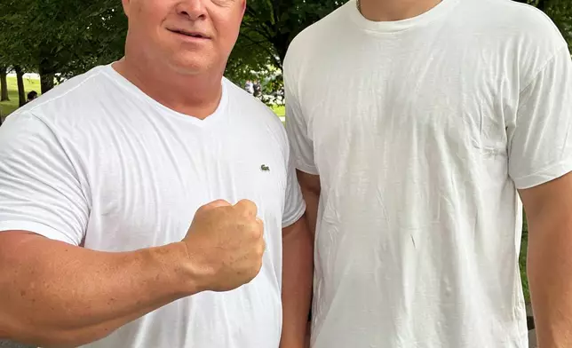Tracy Philbeck and his son, Levi Philbeck, from Charlotte, N.C., pose for a photo at the Lincoln Memorial, Friday, June 12, 2026, in Washington. (AP Photo/Fatima Hussein)