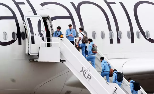England goalkeeper James Trafford, fourth right and teammates board a plane at Birmingham Airport ahead of the team's departure to the United States for the FIFA World Cup, in Birmingham, England, Monday June 1, 2026. (Nick Potts/PA via AP)