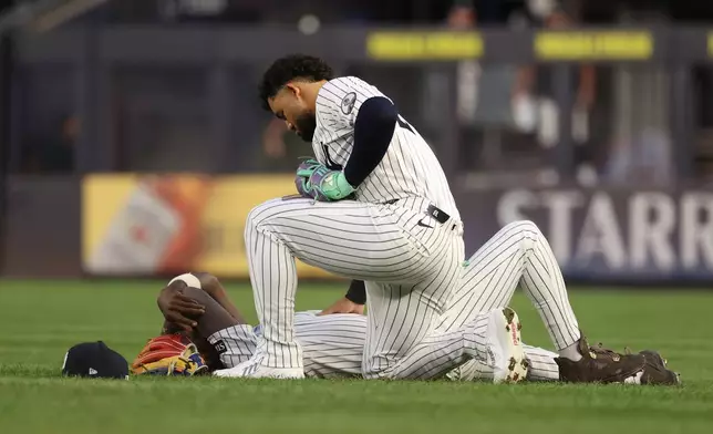 New York Yankees' Jasson Domínguez, top, checks on teammate Jazz Chisholm Jr., bottom, after they collided while pursuing a ball hit by Detroit Tigers' Hao-Yu Lee during the fourth inning of a baseball game Monday, June 29, 2026, in New York. (AP Photo/Pamela Smith)