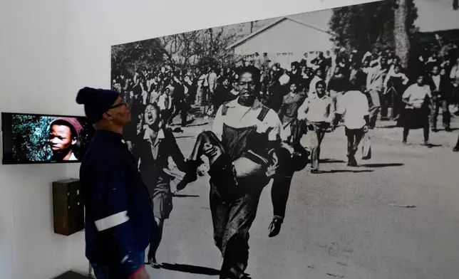 A man looks at June 16 iconic image taken by the late Sam Nzima displayed at The Hector Pieterson Memorial and Museum, in Soweto, South Africa, Monday, June 15, 2026. (AP Photo/Themba Hadebe)