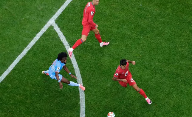 Portugal's Joao Cancelo (20) controls the ball while pursued byCongo's Samuel Moutoussamy (8) as Cristiano Ronaldo, center, looks on during the World Cup Group K soccer match between Portugal and Congo in Houston, Wednesday, June 17, 2026. (AP Photo/Michael Wyke)
