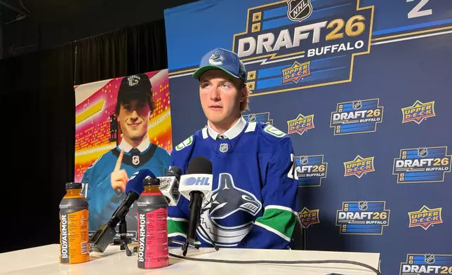 Brooks Rogowski addresses reporters after being selected by the Vancouver Canucks with the first pick in the second round of the NHL draft at the KeyBank Center in Buffalo, N.Y., on Saturday, June 27, 2026. (AP Photo/John Wawrow)