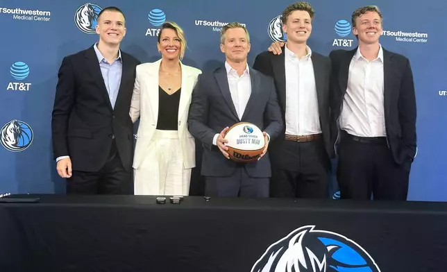New Dallas Mavericks coach Dusty May, center, poses with his family, from left to right, son Eli May, wife Anna May, son Jack May and son Charlie May, during Dusty's introductory NBA basketball news conference in Dallas, Monday, June 29, 2026. (AP Photo/Schuyler Dixon)