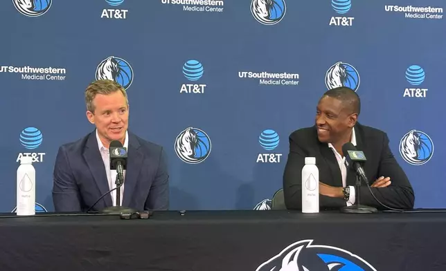 New Dallas Mavericks coach Dusty May, left, and Mavericks president of basketball operations Masai Ujiri, right, speak to the media during May's introductory NBA news conference in Dallas, Monday, June 29, 2026. (AP Photo/Schuyler Dixon)