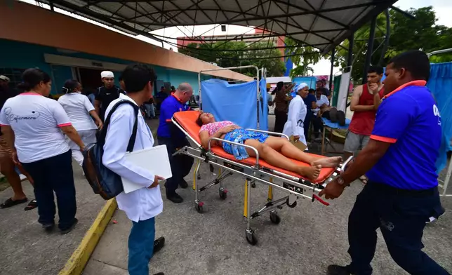 Paramedics carry an injured person at a hospital in Moron,near the epicenter of two earthquakes that struck Venezuela a day earlier, Thursday, June 25, 2026. (AP Photo/Jacinto Oliveros)