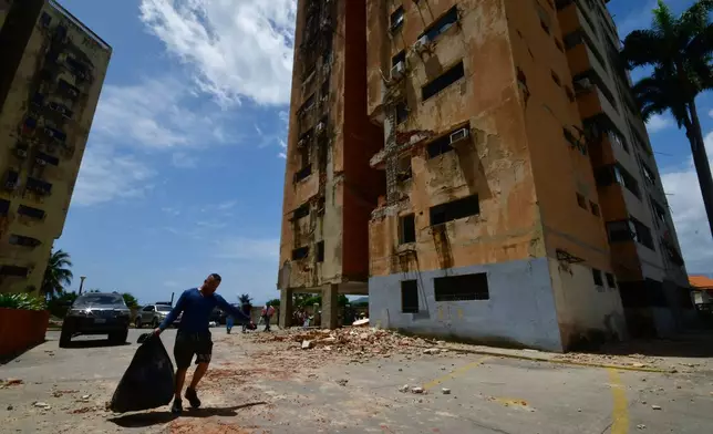 A man walks past a building damaged by earthquakes that struck Puerto Cabello, Venezuela, a day earlier, Thursday, June 25, 2026. (AP Photo/Jacinto Oliveros)