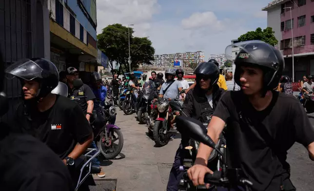 Motorcyclists wait in line to fill their tanks in Caracas, Venezuela, Thursday, June 25, 2026, a day after successive powerful earthquakes struck the country. (AP Photo/Ariana Cubillos)