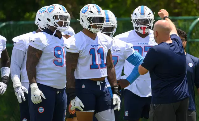 Tennessee Titans defensive end Jermaine Johnson II (11) and Jordan Elliott, left, listen to instruction from defensive line coach Aaron Whitecotton during NFL football practice, Tuesday, June 16, 2026, in Nashville, Tenn. (AP Photo/John Amis)