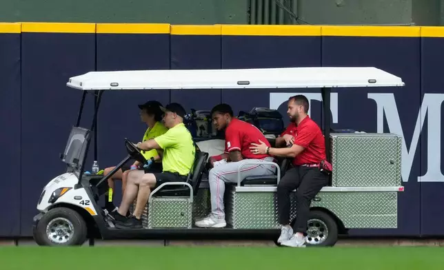Cincinnati Reds' Dane Myers, center, is carted off the field after suffering an injury during the fourth inning of a baseball game against the Milwaukee Brewers, Monday, June 29, 2026, in Milwaukee. (AP Photo/Aaron Gash)
