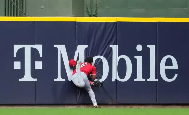 Cincinnati Reds' Dane Myers runs into the wall after making a catch during the fourth inning of a baseball game against the Milwaukee Brewers, Monday, June 29, 2026, in Milwaukee. (AP Photo/Aaron Gash)