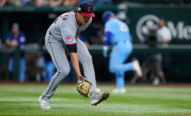 Cleveland Guardians pitcher Joey Cantillo fields an run-scoring infield single hit by Texas Rangers' Jake Burger in the third inning of a baseball game in Arlington, Texas, Sunday, June 7, 2026. (AP Photo/Tony Gutierrez)