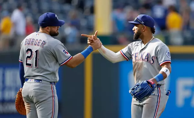 Texas Rangers' Jake Burger (21) and Ezequiel Duran, right, celebrate after their team's win over the Kansas City Royals in a baseball game in Kansas City, Mo., Thursday, June 11, 2026. (AP Photo/Colin E. Braley)