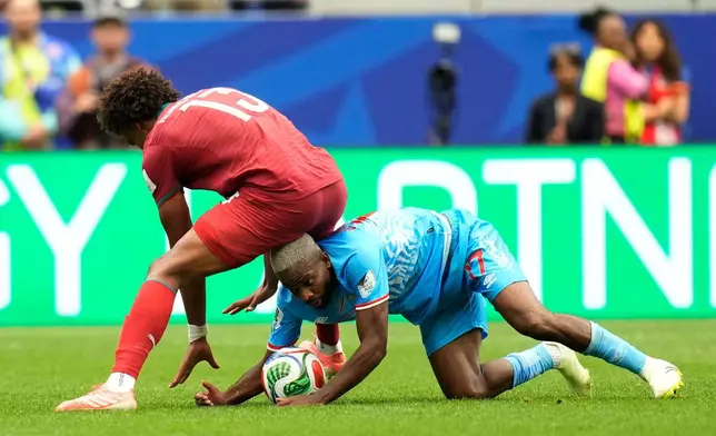 Congo's Cedric Bakambu, bottom, and Portugal's Renato Veiga fight for the ball during the World Cup Group K soccer match between Portugal and Congo in Houston, Wednesday, June 17, 2026. (AP Photo/Karen Warren)