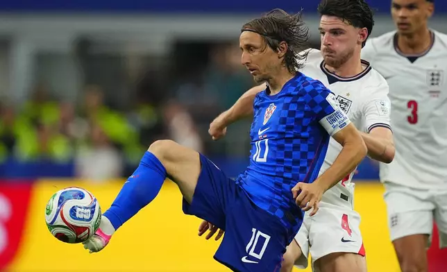 Croatia's Luka Modric, front, kicks the ball pressured by England's Declan Rice during the World Cup Group L soccer match between England and Croatia in Arlington, Texas, near Dallas, Wednesday, June 17, 2026. (AP Photo/Julio Cortez)