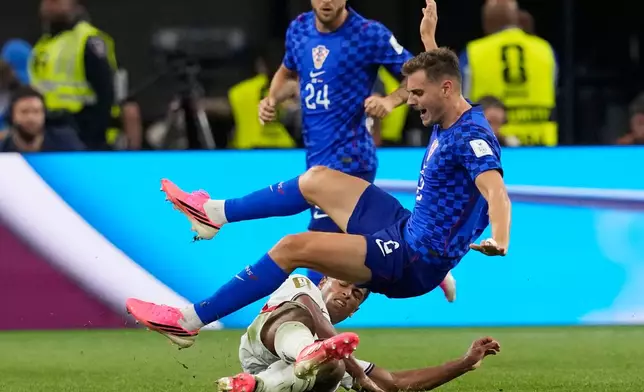 Croatia's Josip Stanisic (2) falls on top of England's Jude Bellingham after Bellingham dove for the ball during the World Cup Group L soccer match between England and Croatia in Arlington, Texas, near Dallas, Wednesday, June 17, 2026. (AP Photo/Tony Gutierrez)