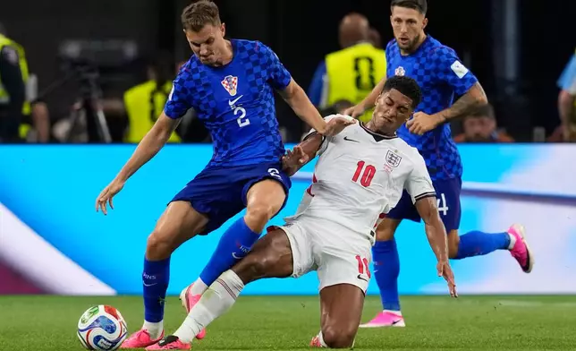 England's Jude Bellingham (10) and Croatia's Josip Stanisic (2) battle for the ball during the World Cup Group L soccer match between England and Croatia in Arlington, Texas, near Dallas, Wednesday, June 17, 2026. (AP Photo/Tony Gutierrez)