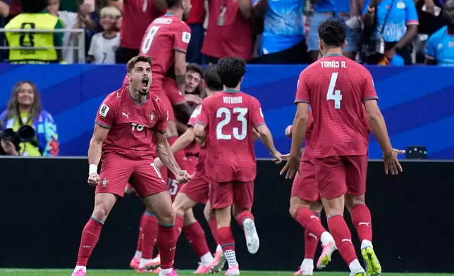 Portugal's Pedro Neto, left, celebrates after teammate Joao Neves scored the opening goalduring the World Cup Group K soccer match between Portugal and Congo in Houston, Wednesday, June 17, 2026. (AP Photo/Ashley Landis)