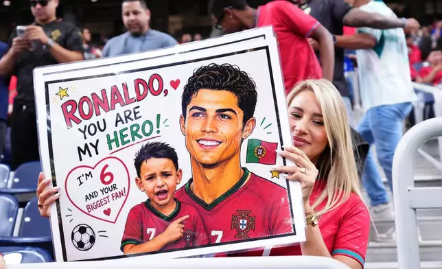 A Portugal supporter holds a banner depicting Cristiano Ronaldo before the World Cup Group K soccer match between Portugal and Congo in Houston, Wednesday, June 17, 2026. (AP Photo/Karen Warren)