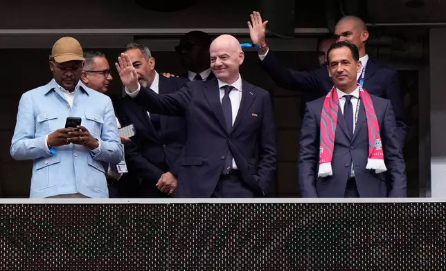 FIFA President Gianni Infantino, center, waves from the tribune next to Portuguese Football Federation President Pedro Proenca, right, and former player Pepe, background right, during the World Cup Group K soccer match between Portugal and Congo in Houston, Wednesday, June 17, 2026. (AP Photo/Ashley Landis)
