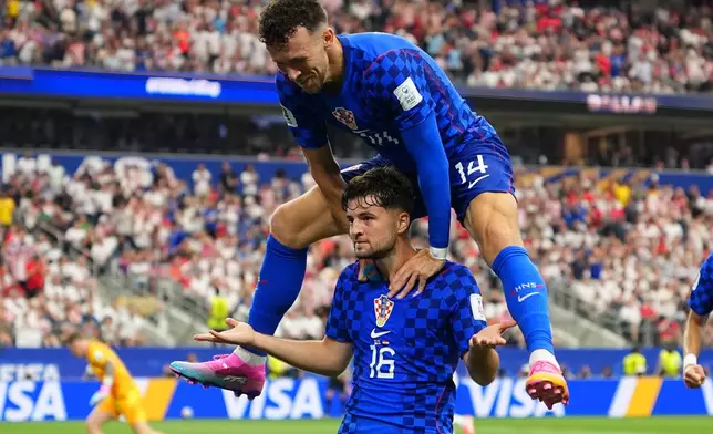 Croatia's Ivan Perisic, top, congrats Martin Baturina after scored during the World Cup Group L soccer match between England and Croatia in Arlington, Texas, near Dallas, Wednesday, June 17, 2026. (AP Photo/Julio Cortez)