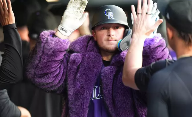 Colorado Rockies' Hunter Goodman celebrates with teammates in the dugout after hitting a two-run home run off Chicago Cubs starting pitcher Colin Rea in the first inning of a baseball game Tuesday, June 9, 2026, in Denver. (AP Photo/David Zalubowski)